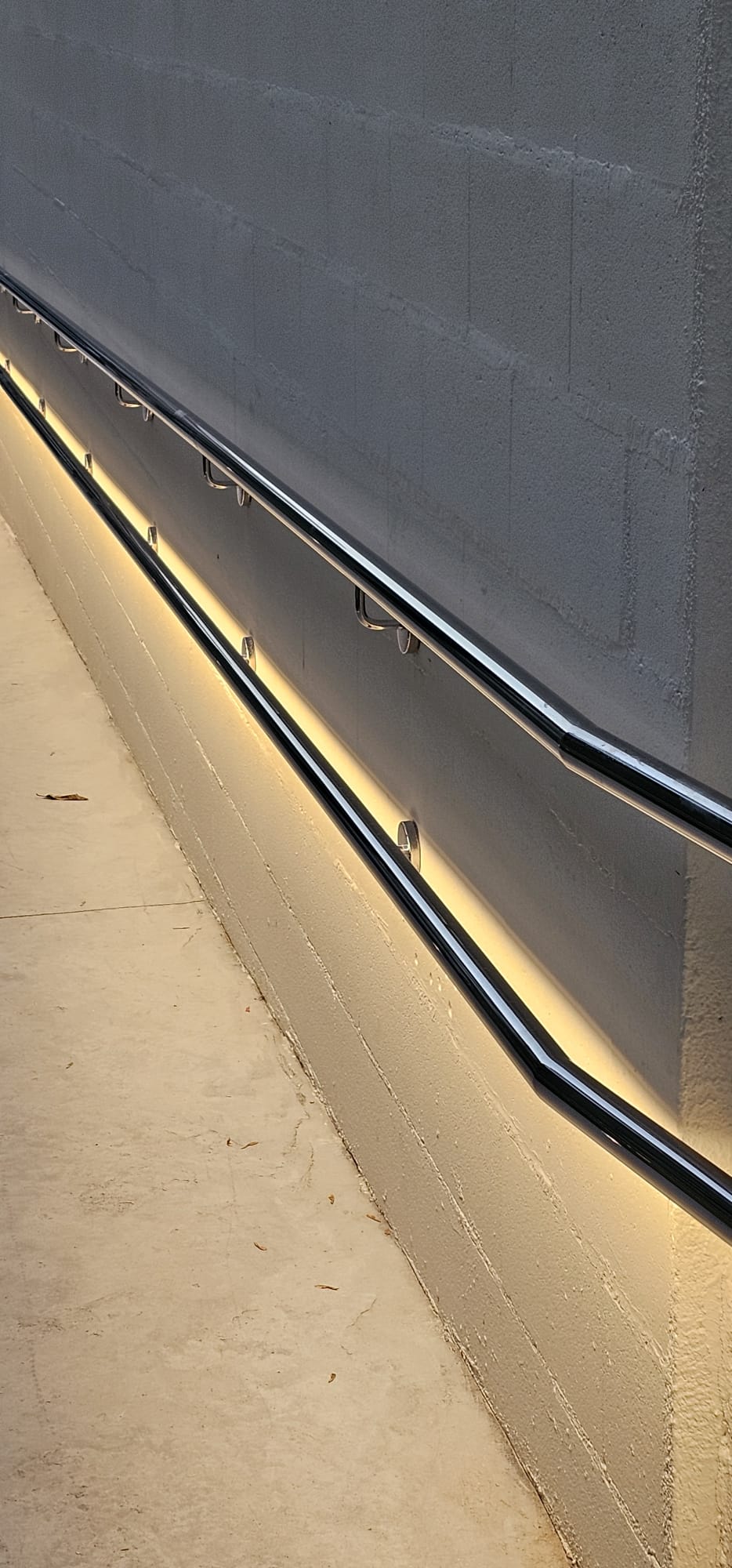 Detalle del pasamanos de acero inoxidable con iluminación indirecta